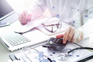 Foto: Arzt arbeitet am Laptop